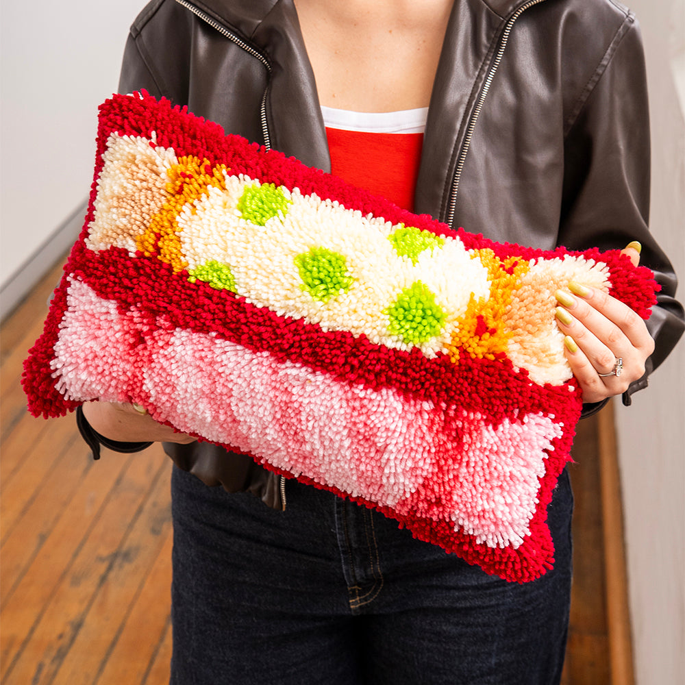 Craft Club CHRISTMAS CRACKERS - Latch Hook Cushion Kit — model holding the finished cushion