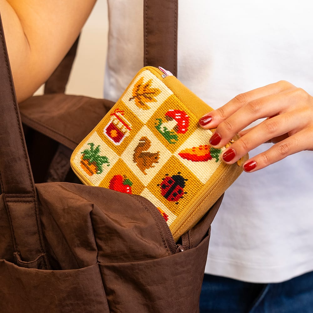 The finished FALL HARVEST CHARMS pouch being lifted out of a brown tote bag