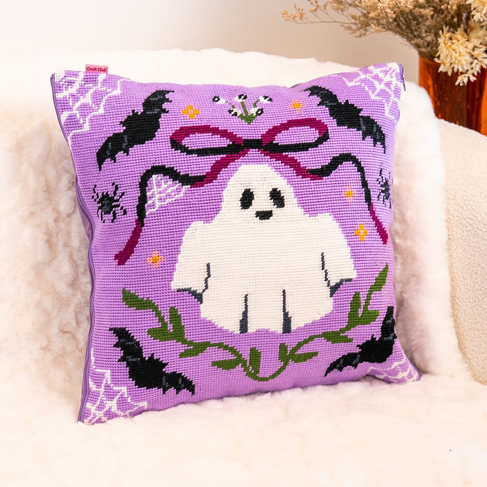 Finished BOO-TIFUL cushion: a white ghost with a maroon bow, black bats and green vines on lilac