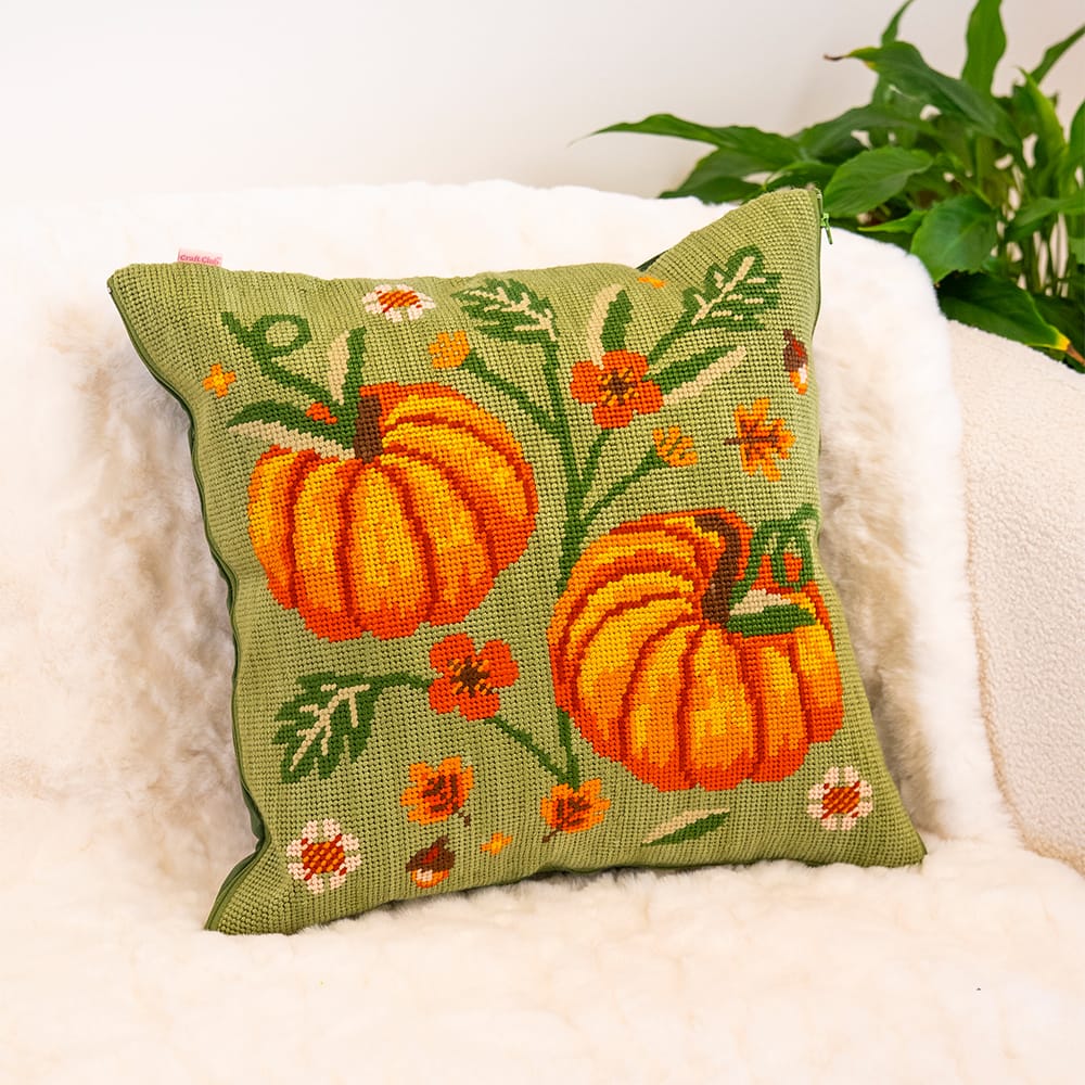 Finished COTTAGE PUMPKINS cushion: two orange pumpkins, vines and small flowers on sage green