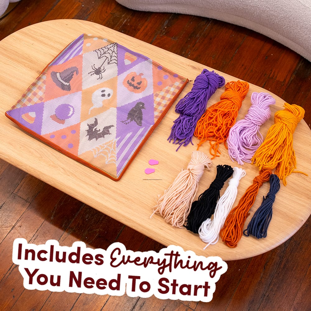 Everything in the SPOOKY TROVES kit: printed canvas, purple, orange, black and cream yarn, needle threader