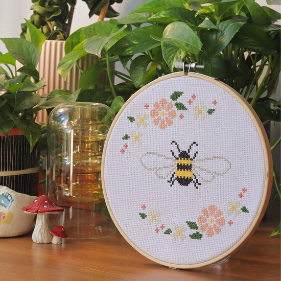 Craft Club Co BEE & BLOSSOM Cross Stitch Kit. The design from a side angle, showing pot plants and a decorative mushroom next to it.