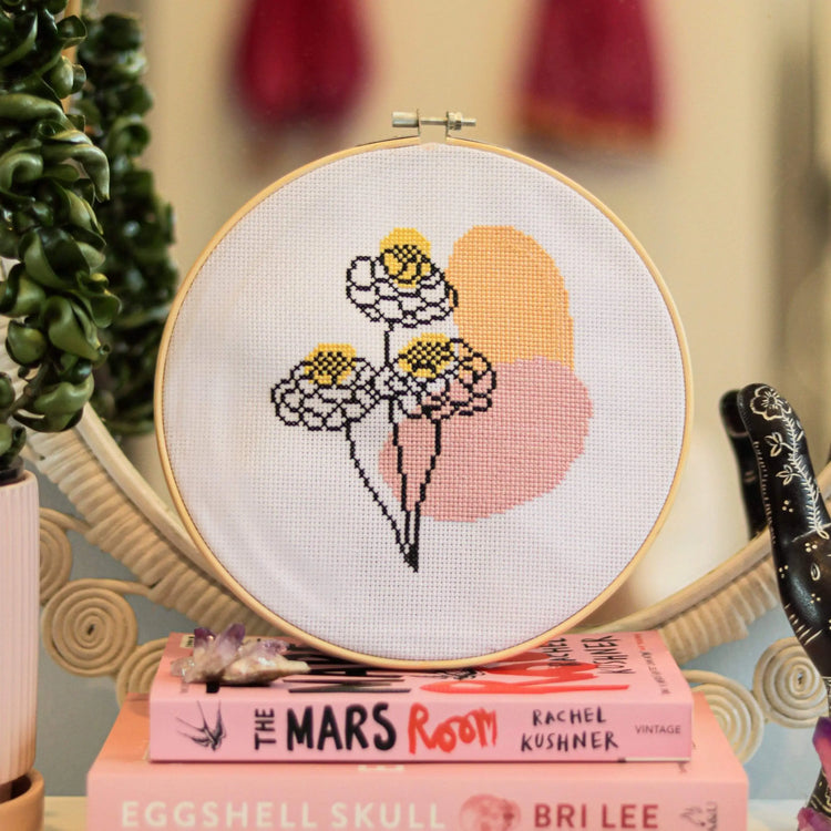 Craft Club Co BLOOM Cross Stitch Kit. The design is shown on a different stack of books with a pink colour scheme.