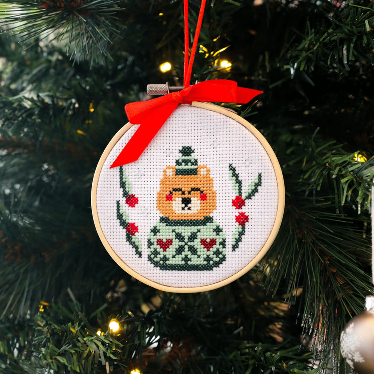 Craft Club Co CHRISTMAS MINI ORNAMENTS Cross Stitch Kit. A close up of the bear design, showing the stitching details on the bears sweater and the holly around it.