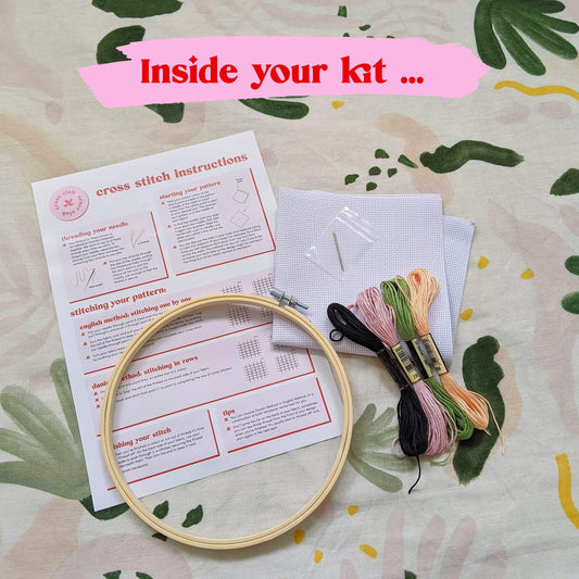 Craft Club Co PEACHY KEEN Cross Stitch Kit. Showing what is inside the kit, a bamboo hoop, instructions, aida fabric, full packs of thread and a needle.