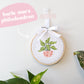 Craft Club Co POT PLANT MINIS Cross Stitch Kit. A close up of the burle marx philodendron, showing it's bright green leaves, yellow veins and light pink pot.