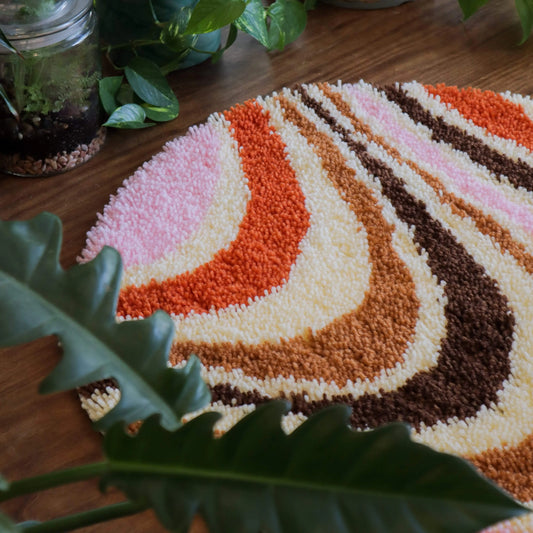 Craft Club Co CARAMEL SWIRL Rug Making Kit. Close up of the top of the rug, showing pink, cream, orange and brown yarn.